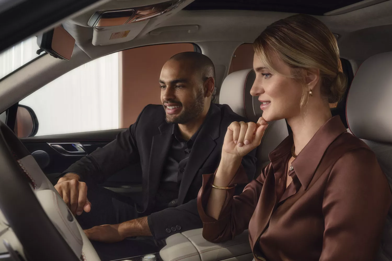 Genesis Concierge in passenger seat speaking to woman in driver seat, inside Genesis GV80 Coupe