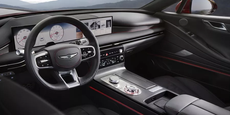 Interior front driver side pov of steering wheel and digital dashboard in Genesis G80