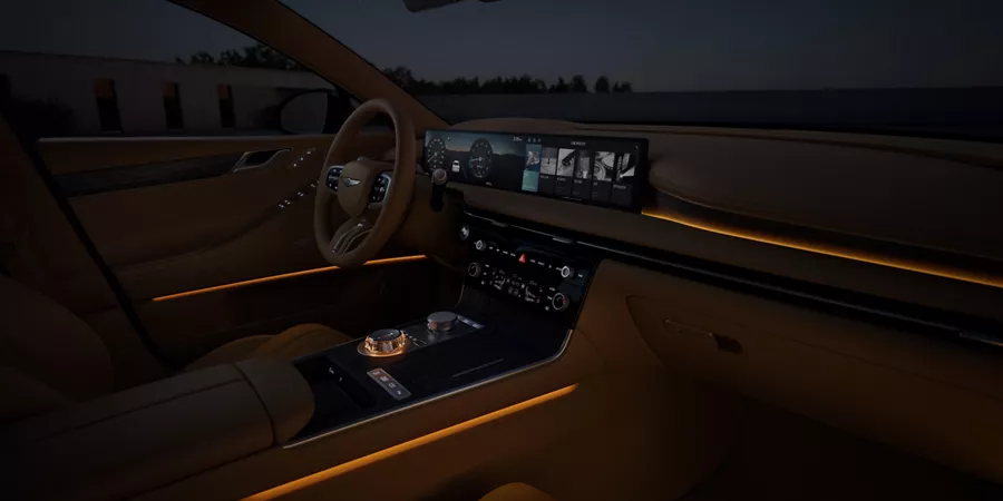 Interior passenger seat pov of Genesis G80 cockpit at night, orange ambient lights turned on