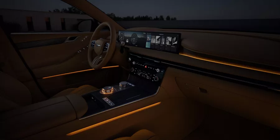 Front passenger POV of Genesis G80 interior with orange ambient lights turned on