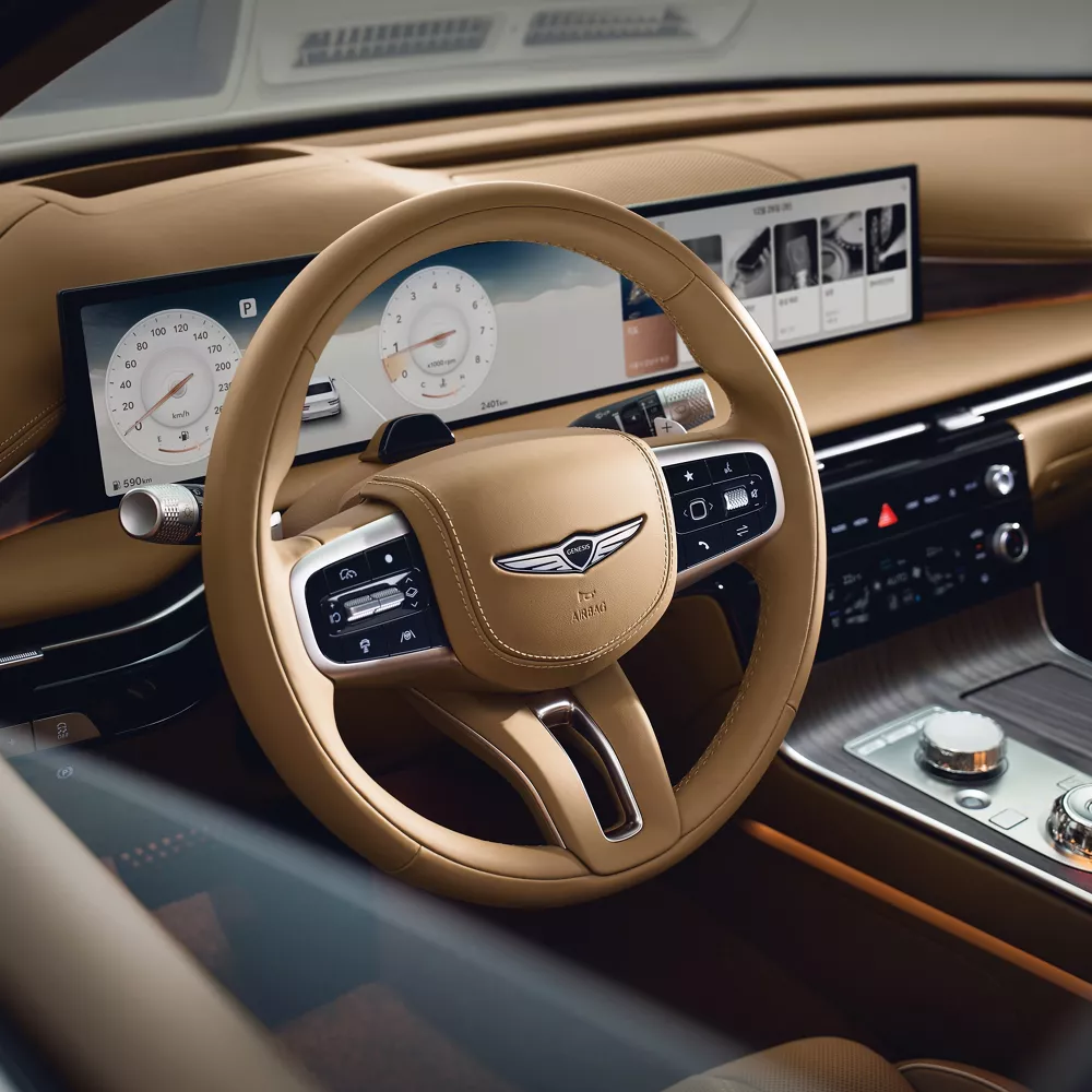 Interior Driver side close-up of Genesis G80 steering wheel in beige