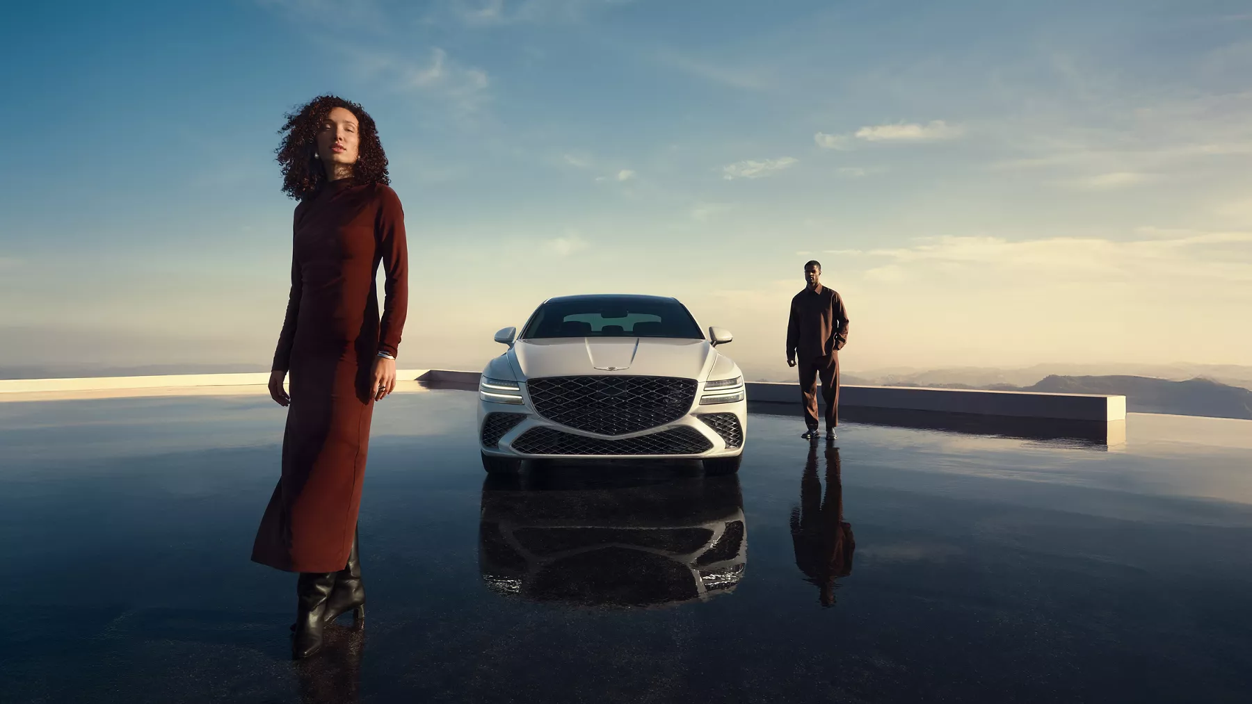 Genesis G80 in Uyuni White parked on a reflective terrace with modern architecture at sunset