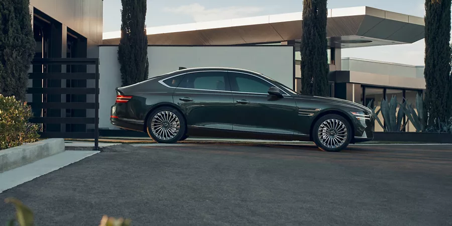 Side profile view of Genesis Electrified G80 parked in a driveway