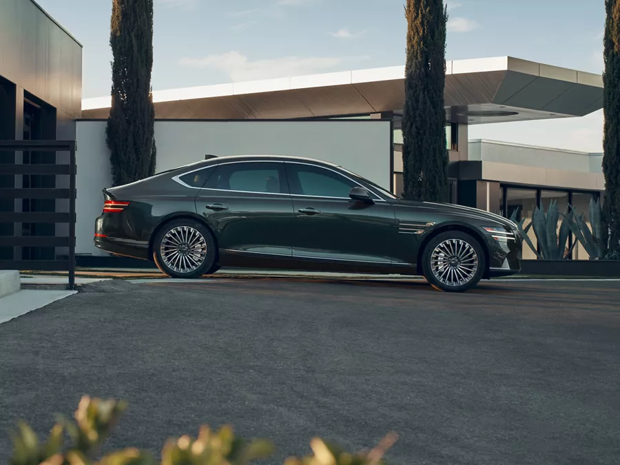 Side profile view of Genesis Electrified G80 parked in a driveway