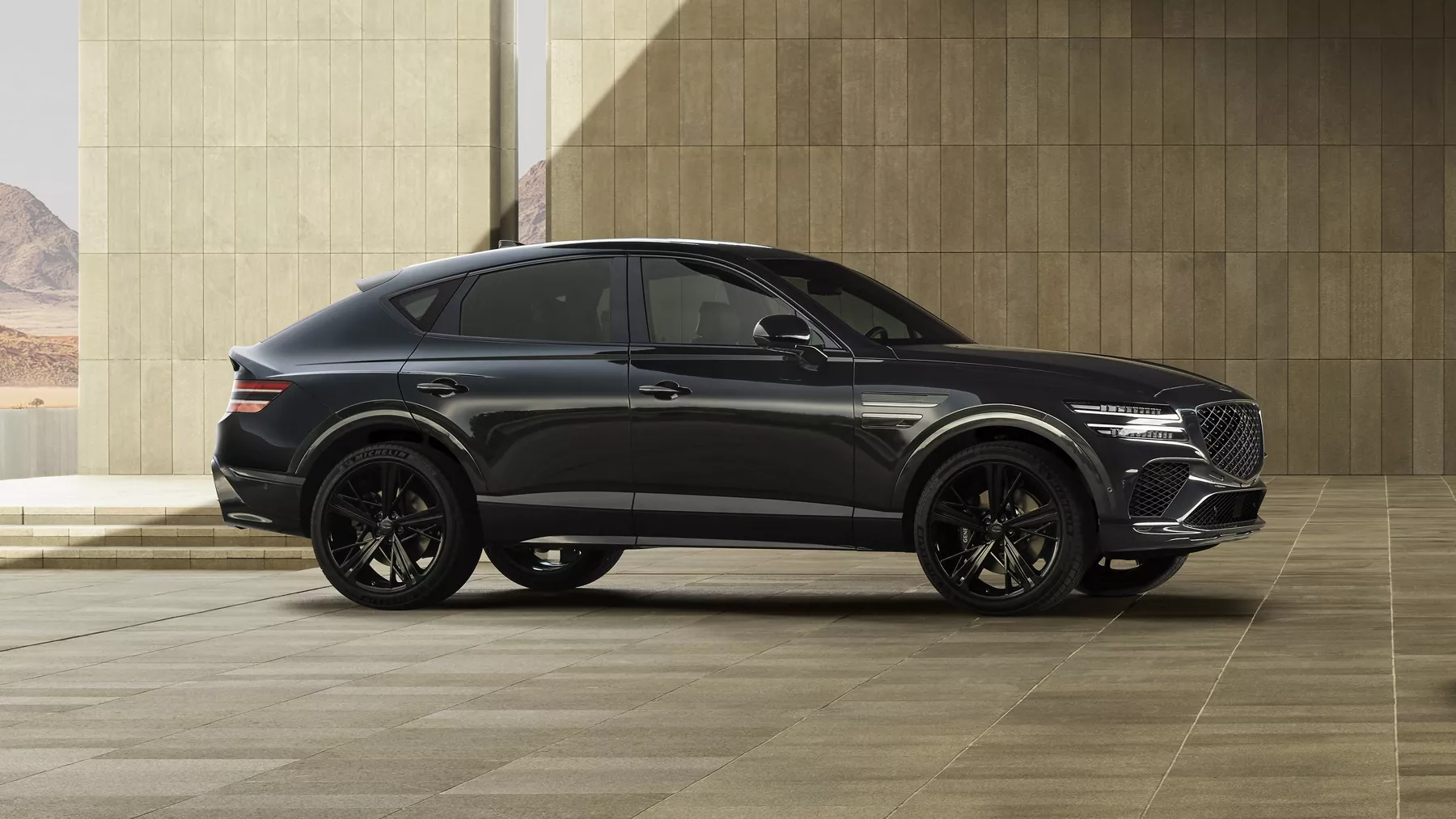 Passenger side profile view of Genesis GV80 Coupe Prestige Black parked in front of modern building
