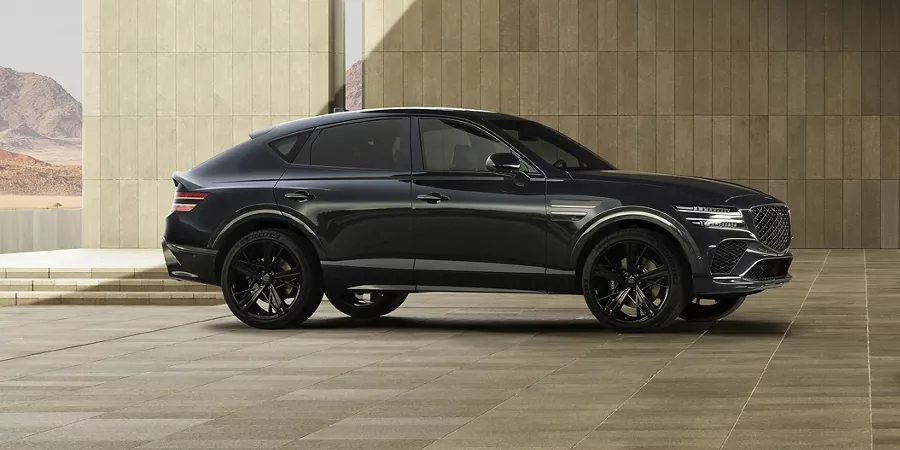 Passenger side shot of Genesis GV80 Coupe Prestige Black parked under a bridge
