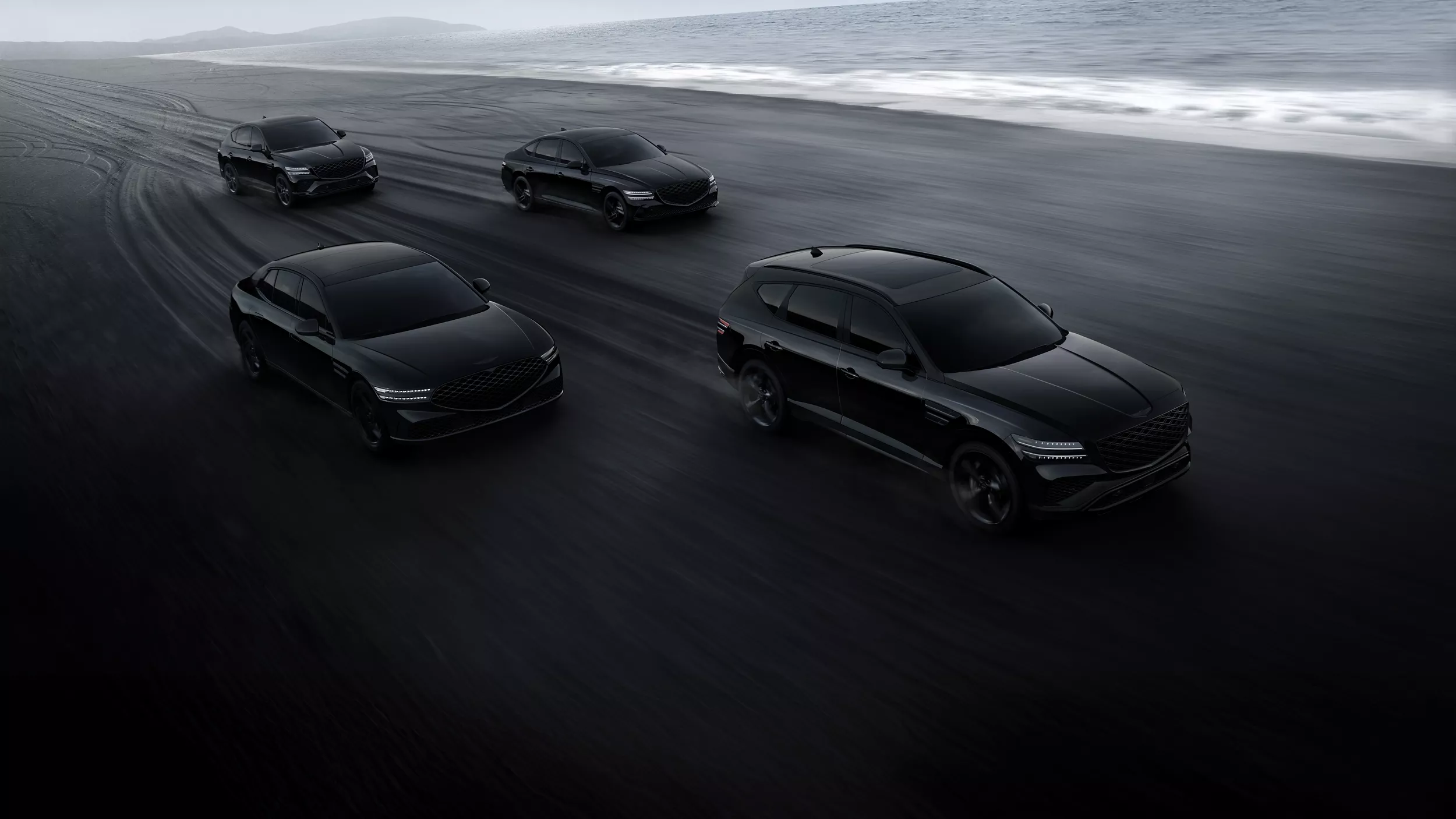 2026 Genesis G90, G80, GV80, and GV80 Coupe Prestige Black vehicles driving along beach shoreline