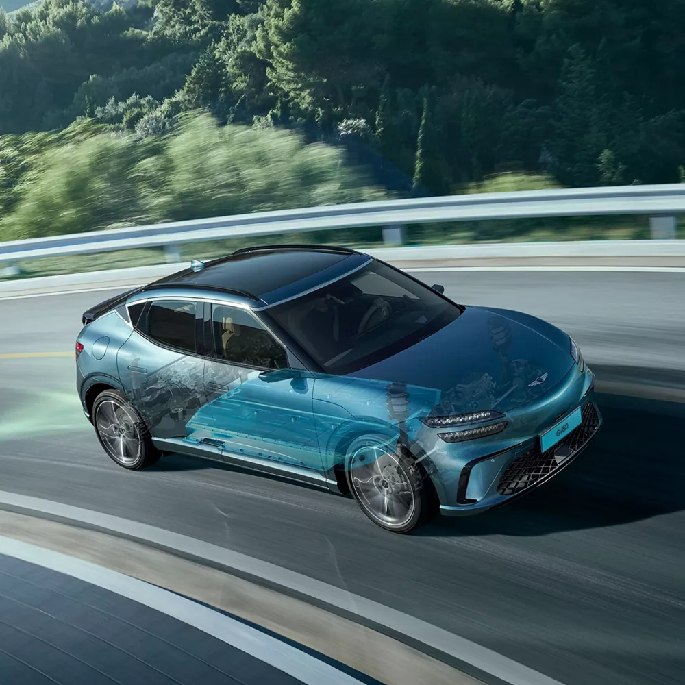 2026 Genesis GV60 on mountain road, with computer generated cross section of suspension system