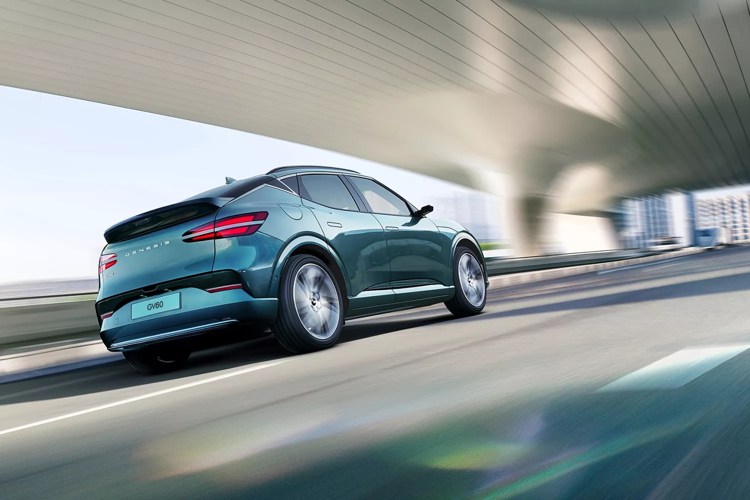 3/4 rear passenger side view of 2026 Genesis GV60 in Tromso Green driving under modern bridge