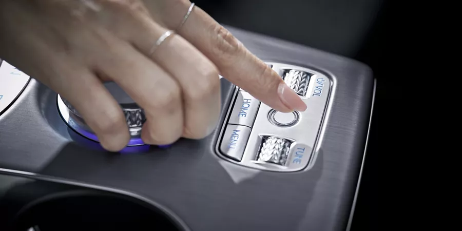 Interior close up of hand pressing "control" button on 2026 Genesis GV60's center console