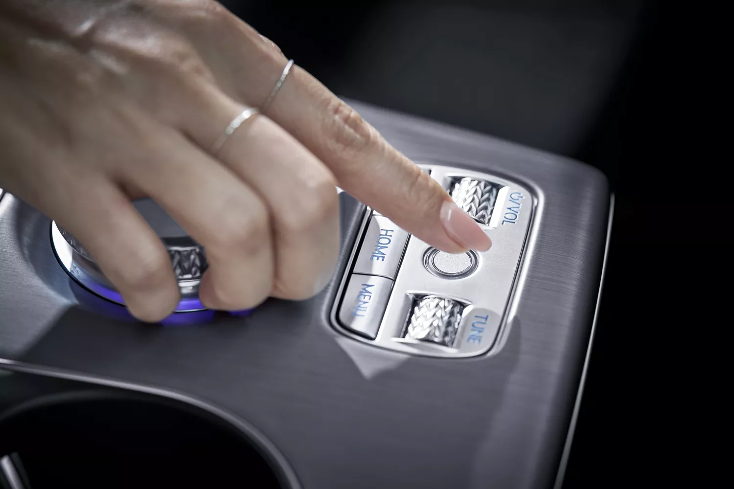 Interior close up of hand pressing "control" button on 2026 Genesis GV60's center console
