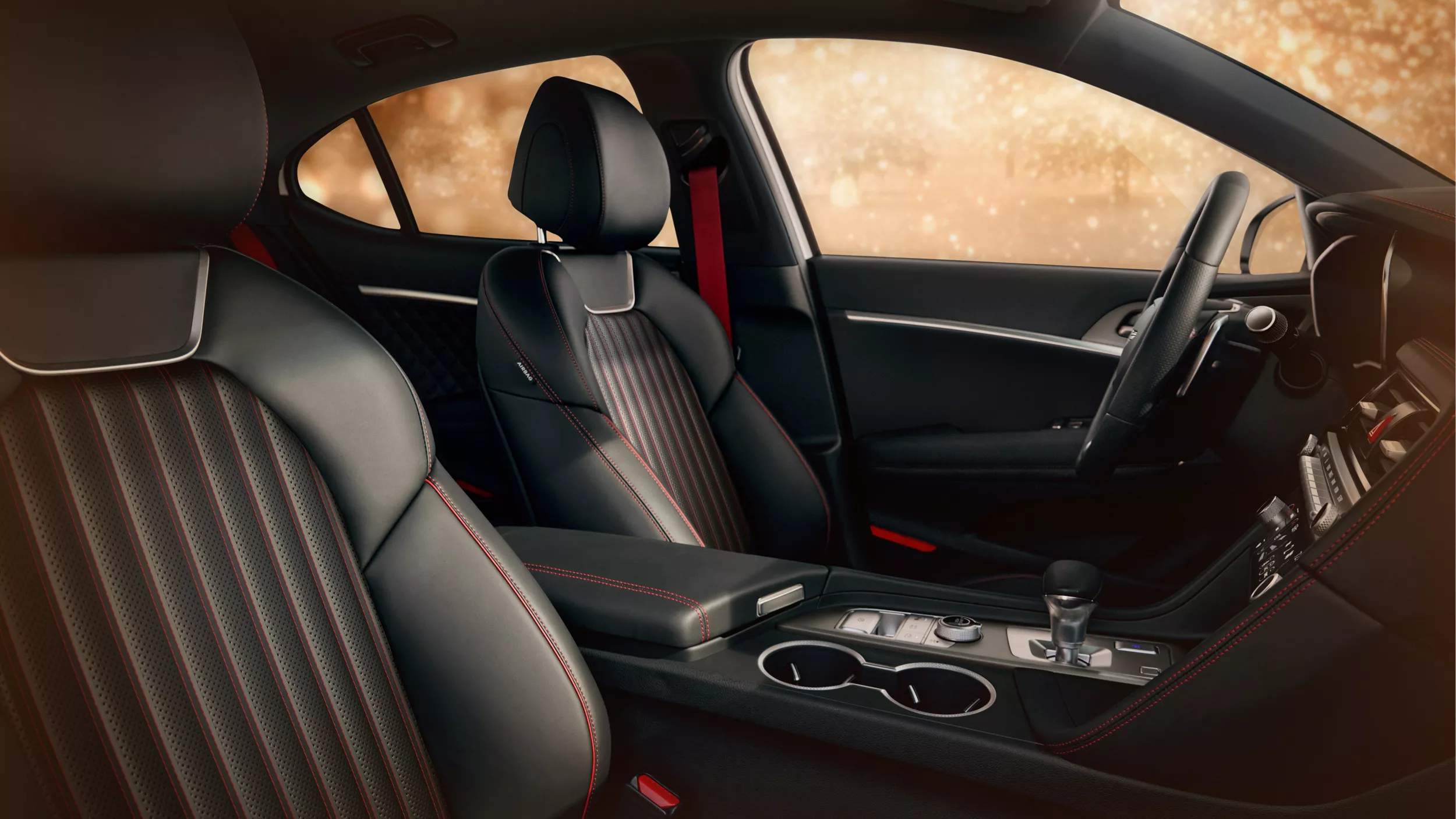 Interior front passenger pov of driver side inside Genesis G70 with black leather and red stitching