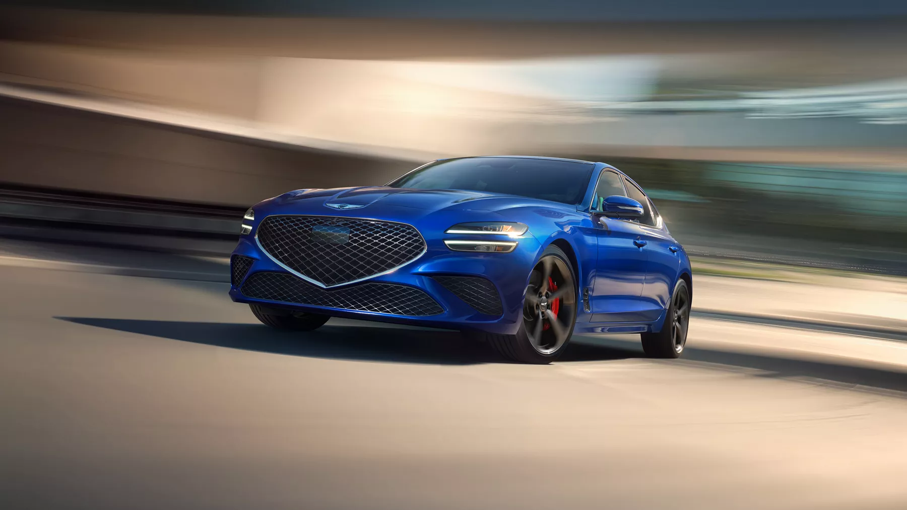 Front driver side view of Genesis G70 3.3T Sport Prestige in Kawah Blue with blurred background
