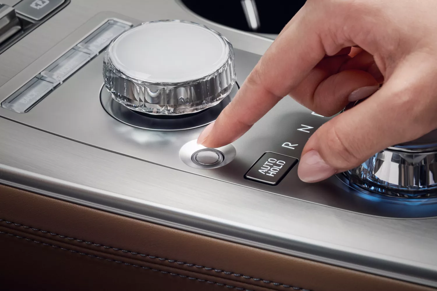 Interior view of driver pressing Fingerprint Authentication button on center console of Genesis GV70