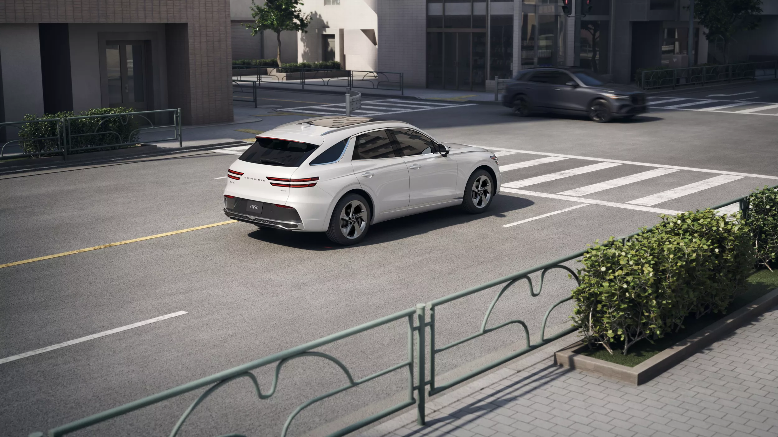 3/4 rear passenger side view of Genesis GV70 in Uyuni White, driving up to crosswalk in city