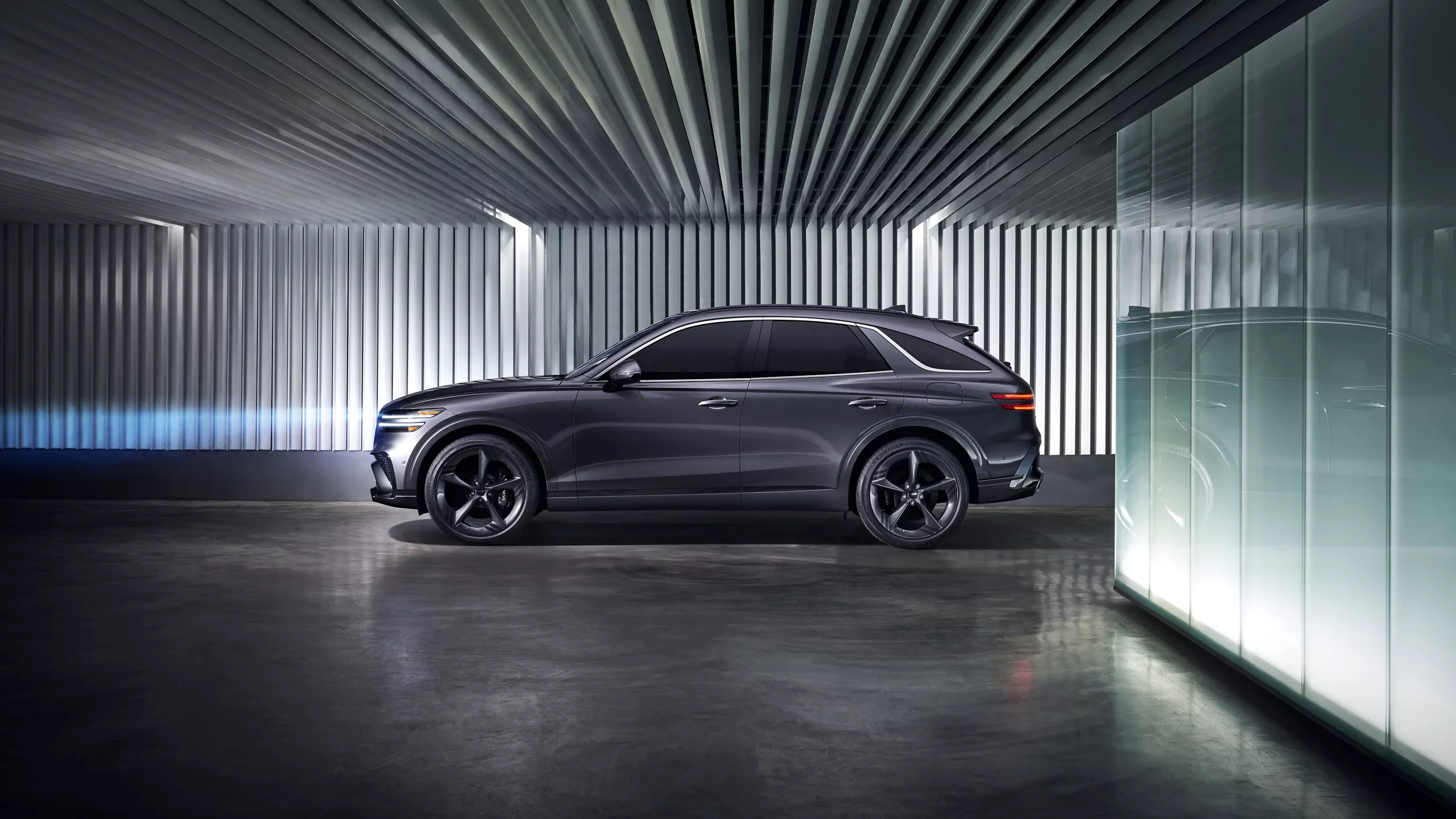 Driver side profile view of Genesis GV70 parked in industrial-style garage