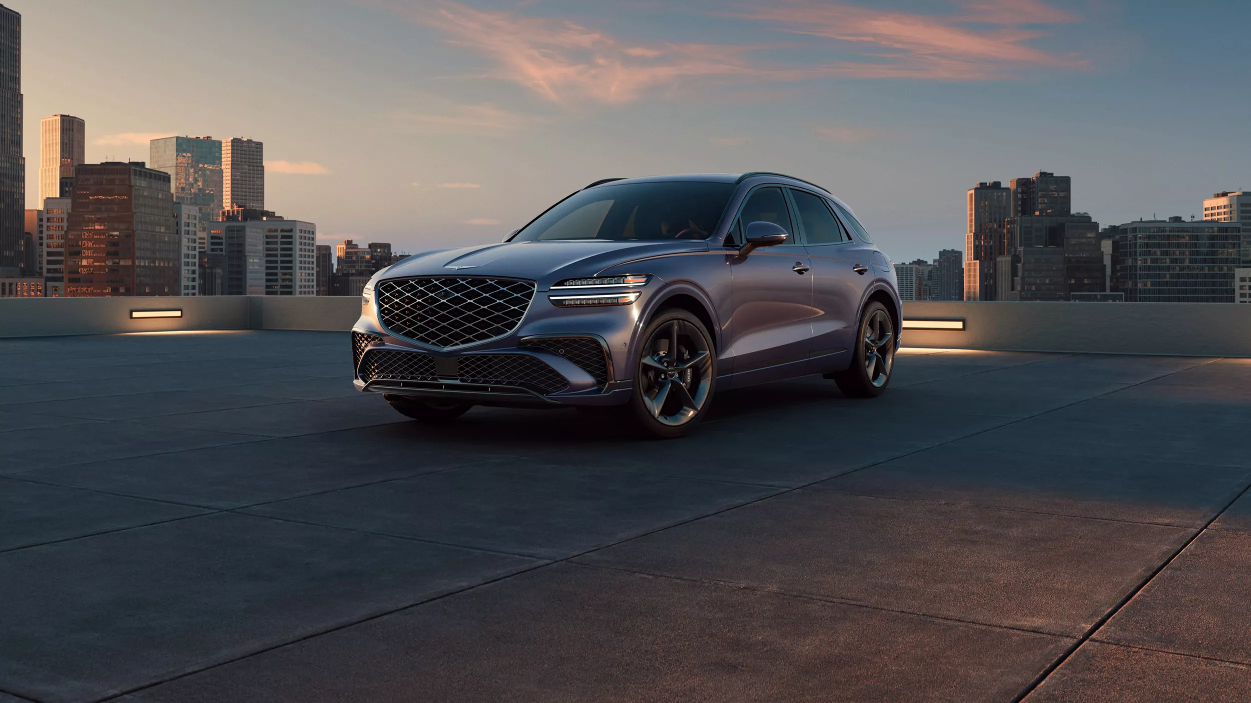 3/4 front driver side view of Genesis GV70 on rooftop with city skyline in background