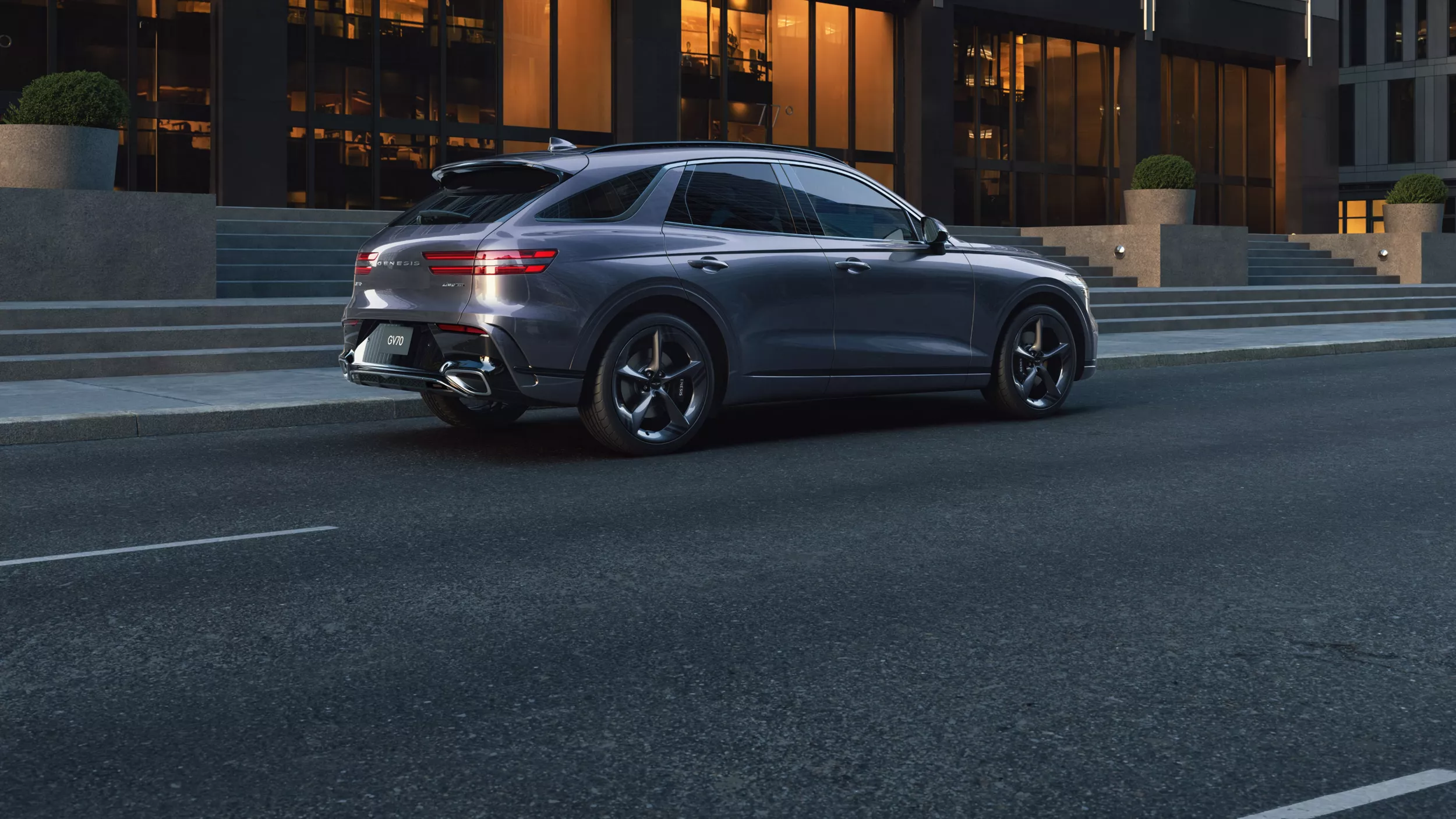 Passenger side profile view of Genesis GV70 parked on city street