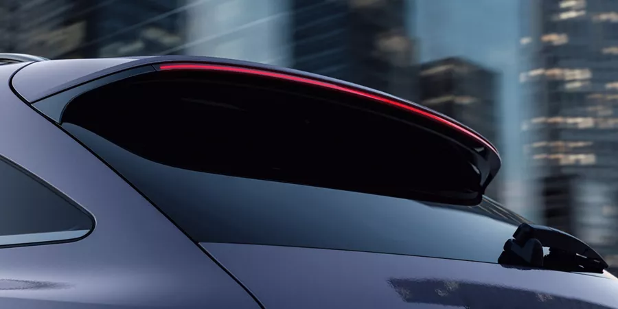Rear driver side close-up of 2026 Genesis GV70 LED tail lights against blurred city skyline