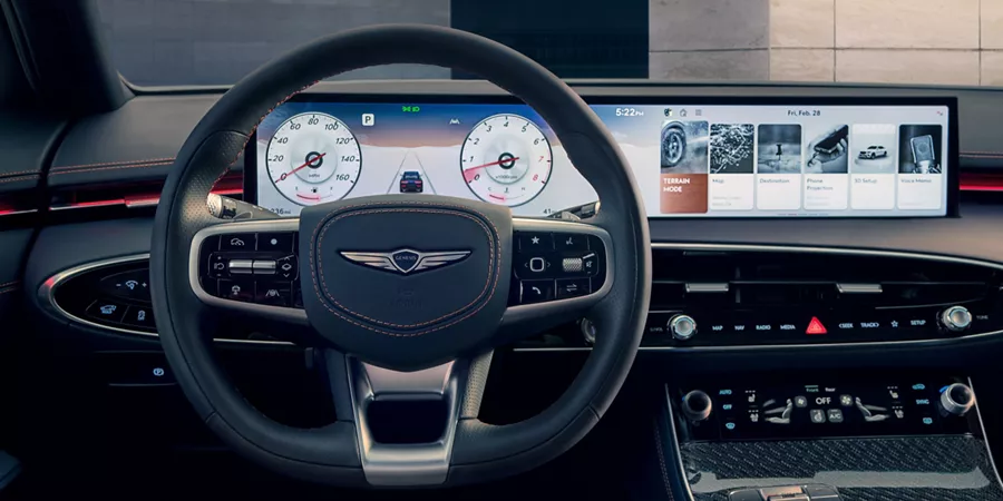 Interior driver seat pov close-up of 2026 Genesis GV70 D-cut steering wheel and digital dashboard