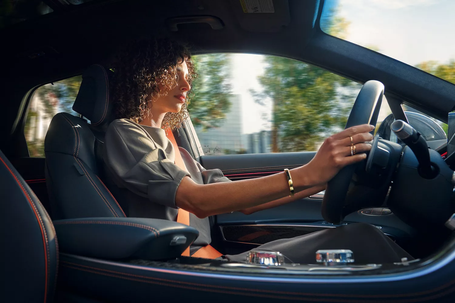 Interior view from passenger seat of woman driving Genesis GV70