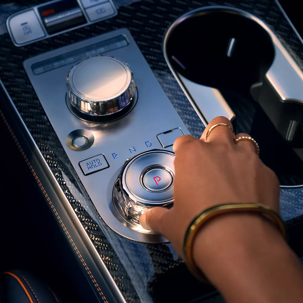 2026 Genesis GV70 interior close up of shift-by-wire gear selector and premium center console design