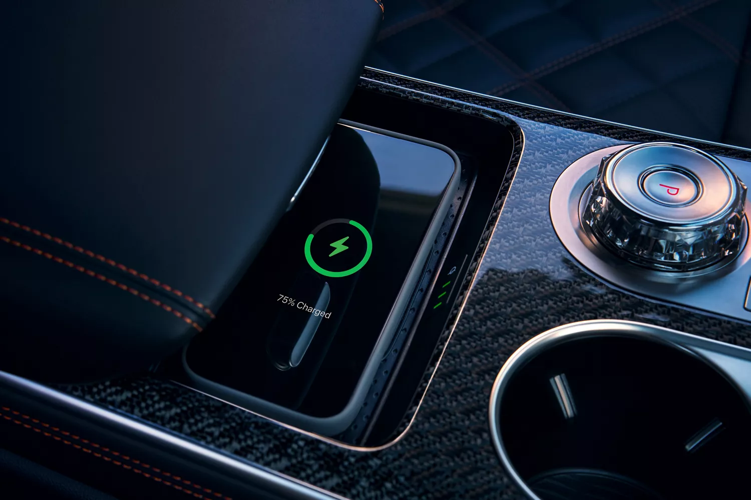 Close-up of 2026 Genesis GV70 center console with wireless charging mat, armrest, and cup holder