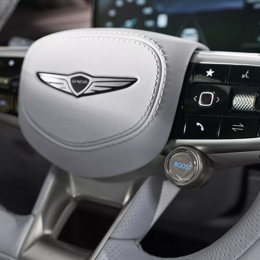 Closeup of Genesis emblem on steering wheel of Genesis Electrified GV70
