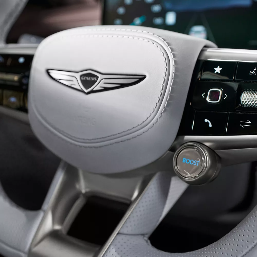 Closeup of Genesis emblem on steering wheel of Genesis Electrified GV70