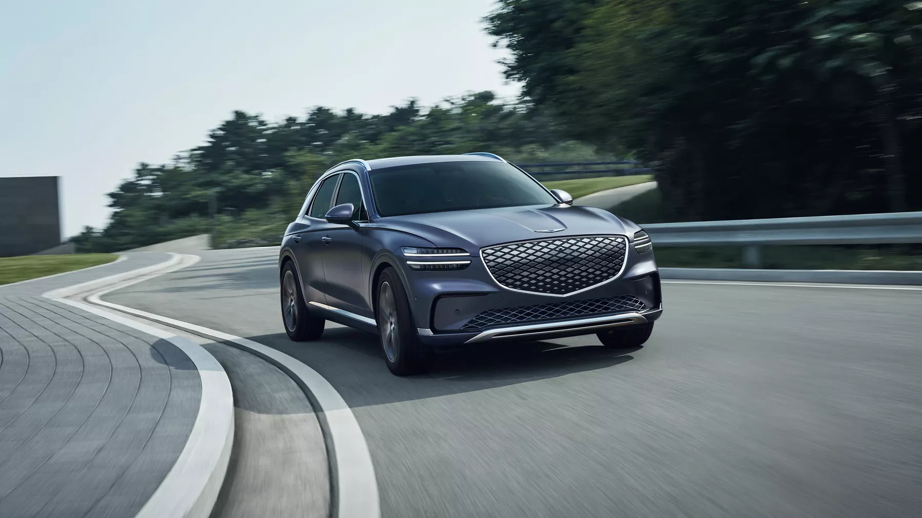 3/4 front passenger side view of Genesis Electrified GV70 in Ceres Blue driving on road