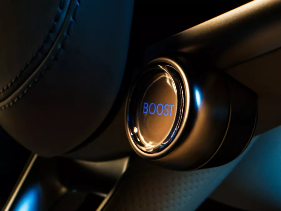 Interior closeup of Boost mode button on steering wheel inside Genesis Electrified GV70