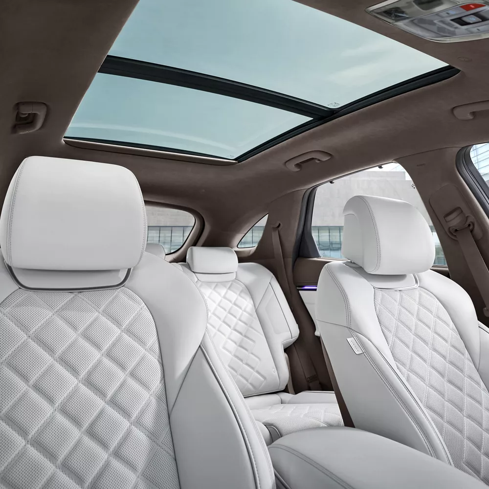 Interior view of white quilted nappa leather front and rear seats inside Genesis Electrified GV70