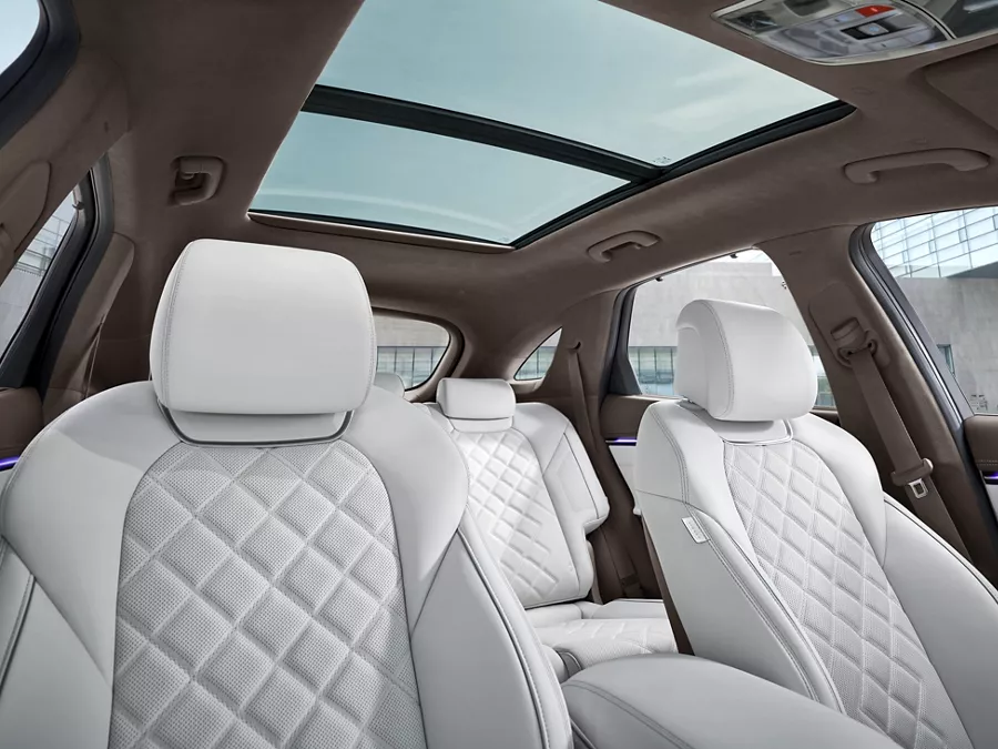Interior view of white quilted nappa leather front and rear seats inside Genesis Electrified GV70