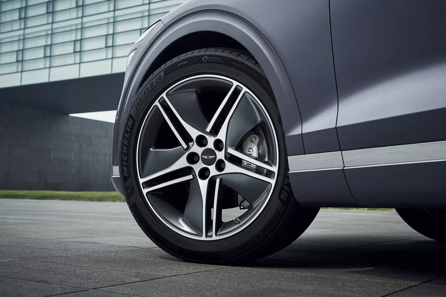 Front driver side closeup of wheels on Genesis Electrified GV70 in Ceres Blue
