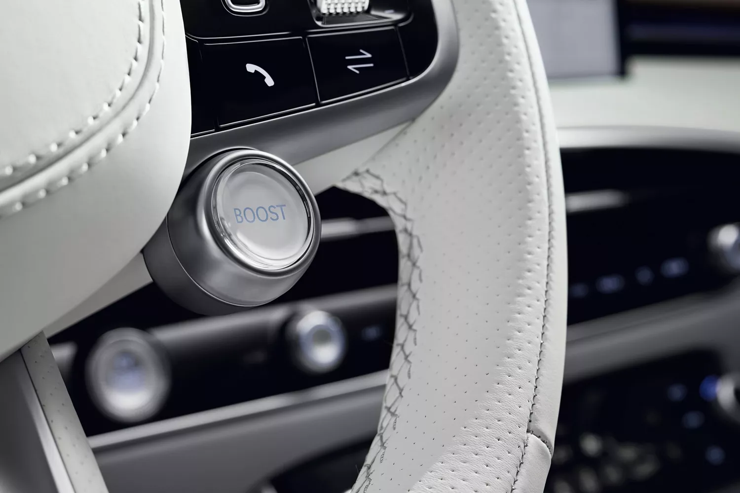 Interior closeup of Boost mode button on steering wheel inside Genesis Electrified GV70