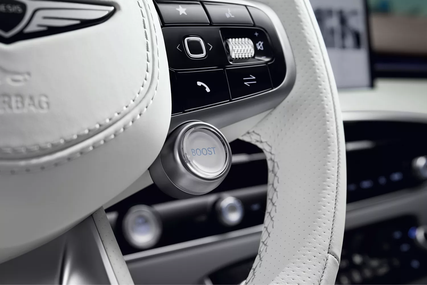 Interior closeup of white leather steering wheel and controls in side Genesis vehicle
