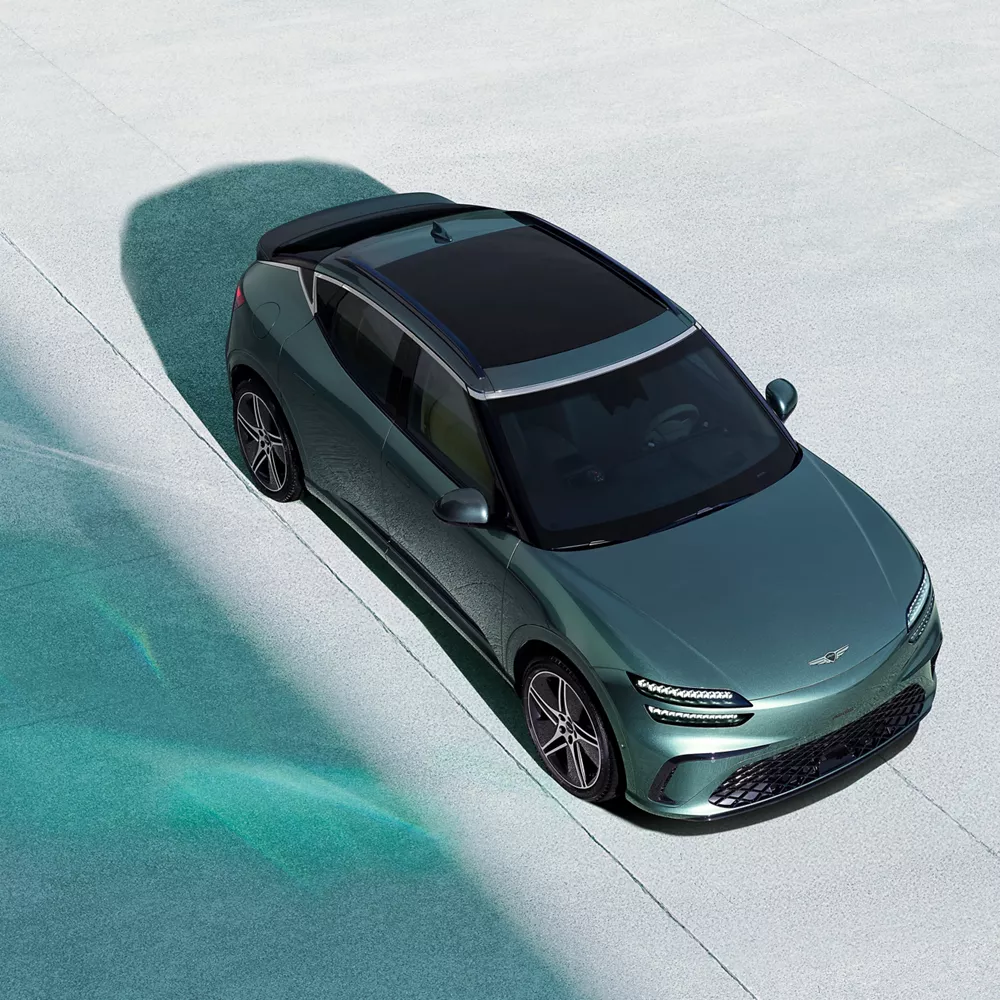 Top-down view of 2026 Genesis GV60 in Tromso Green on concrete surface