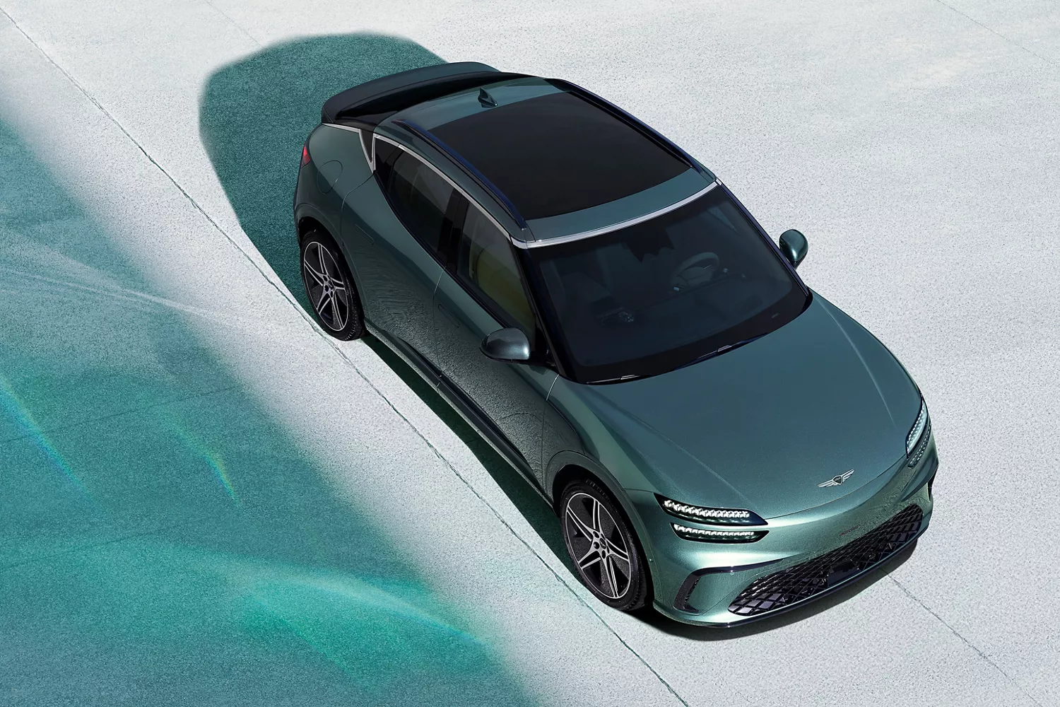 Top-down view of 2026 Genesis GV60 in Tromso Green on concrete surface