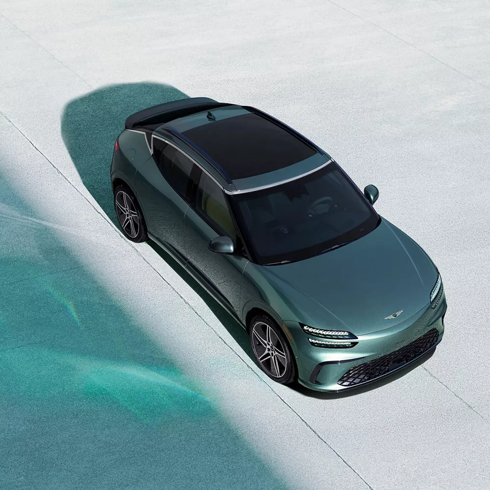 Top-down view of 2026 Genesis GV60 in Tromso Green on concrete surface