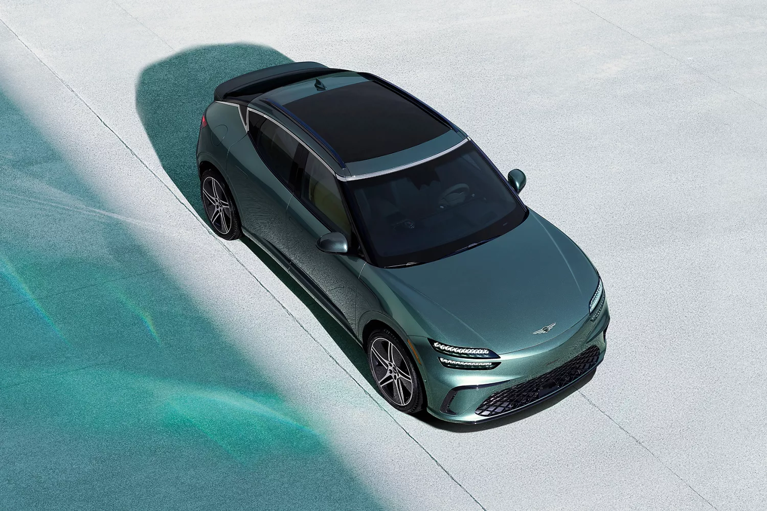 Top-down view of 2026 Genesis GV60 in Tromso Green on concrete surface