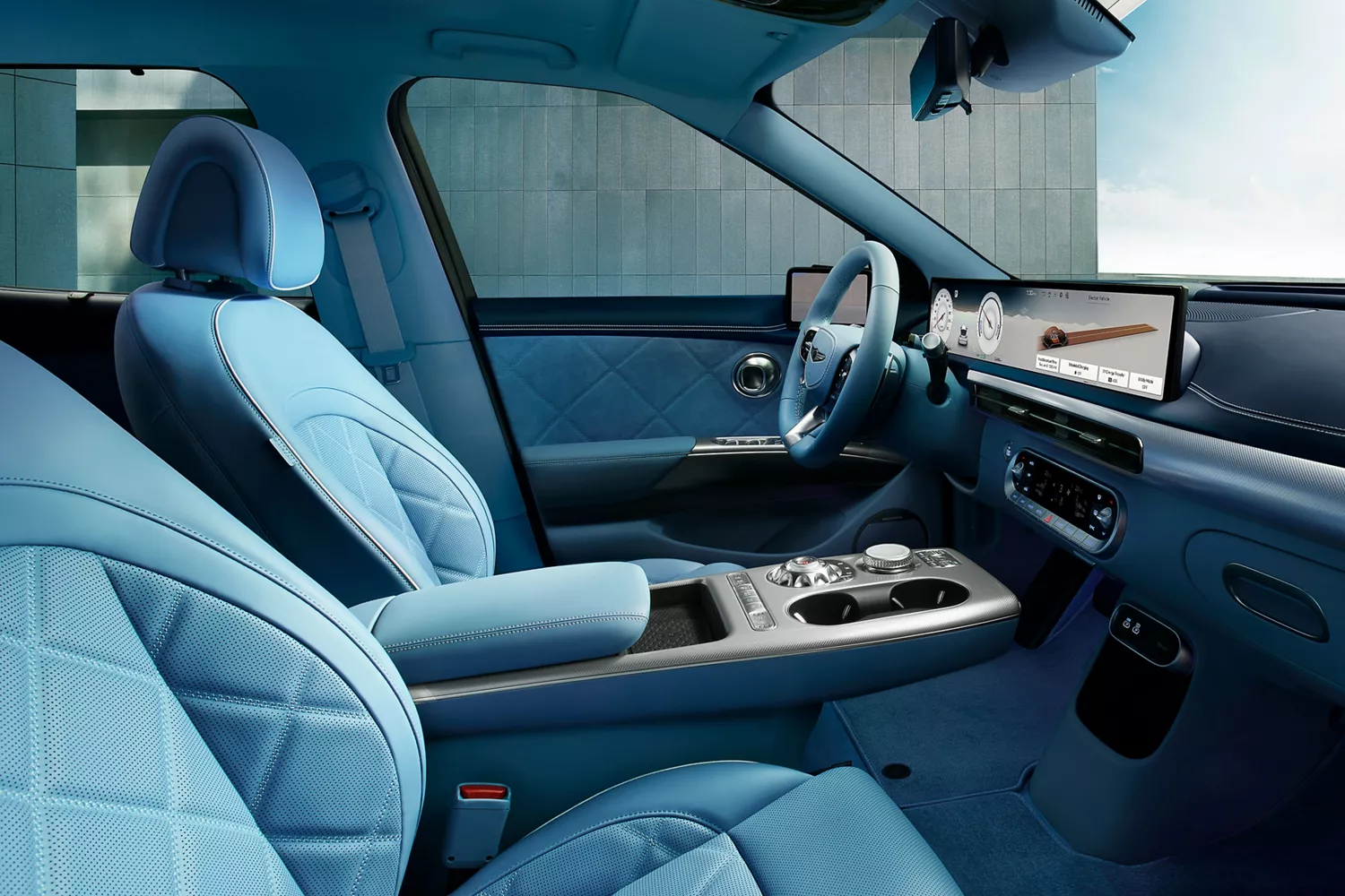 Interior passenger side cabin view of 2026 Genesis GV60 with blue quilted nappa leather seats