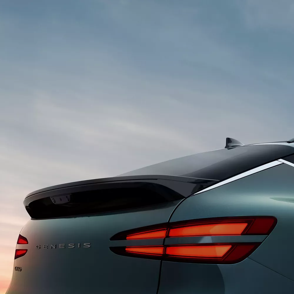 3/4 rear passenger side close up of 2026 Genesis GV60 in Tomso Green under dusky sky