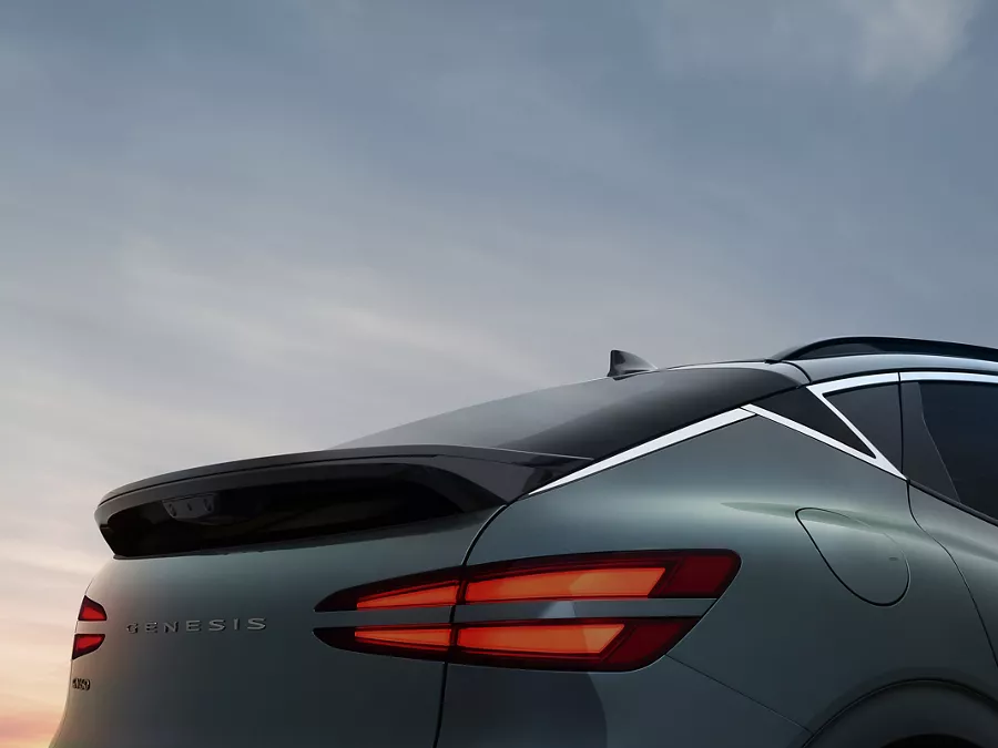 3/4 rear passenger side close up of 2026 Genesis GV60 in Tomso Green under dusky sky