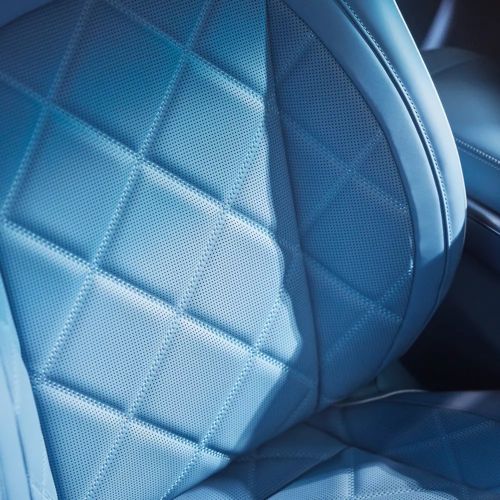 Close up interior shot of 2026 Genesis GV60 blue nappa leather seat with diamond quilting