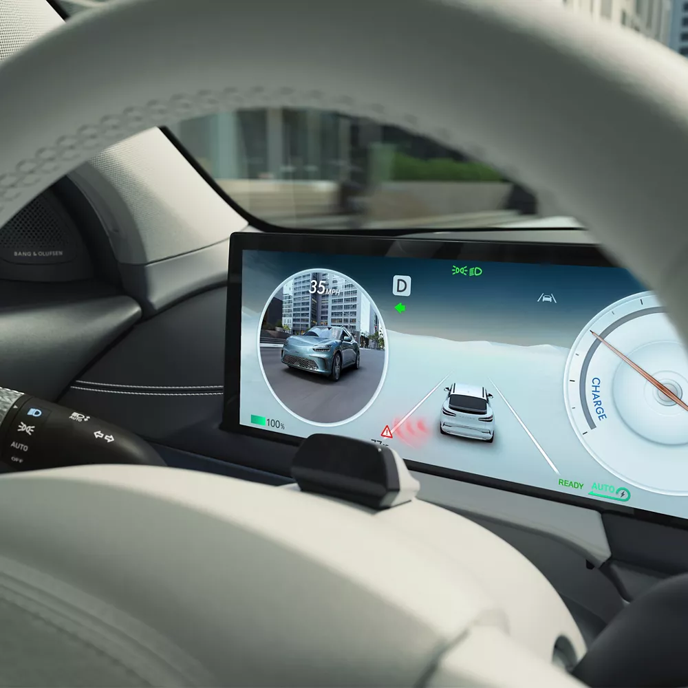 Interior close up of 27 inch OLED information display through steering wheel, inside Genesis GV60