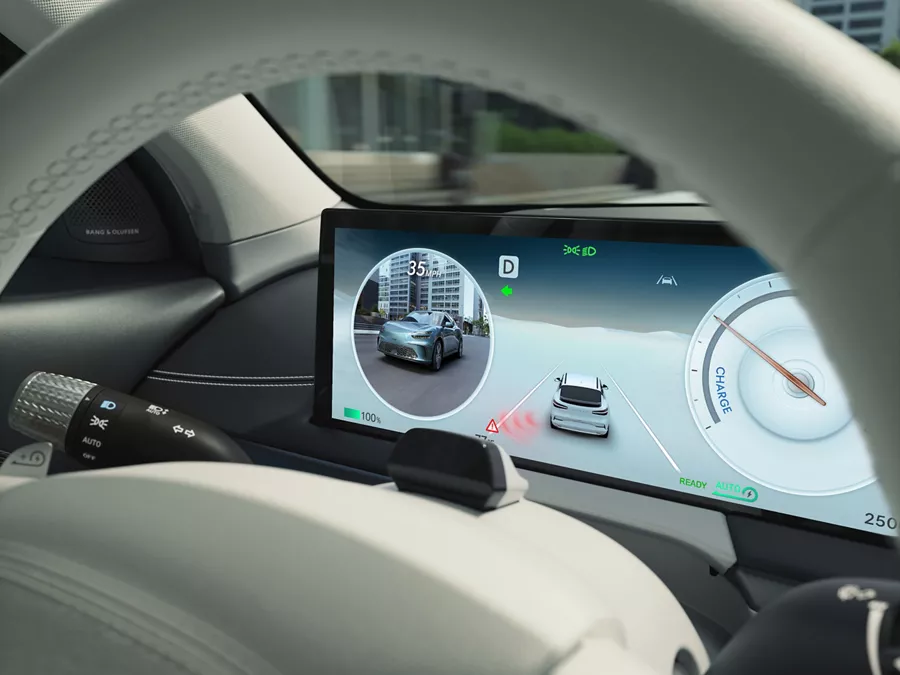 Interior close up of 27 inch OLED information display through steering wheel, inside Genesis GV60