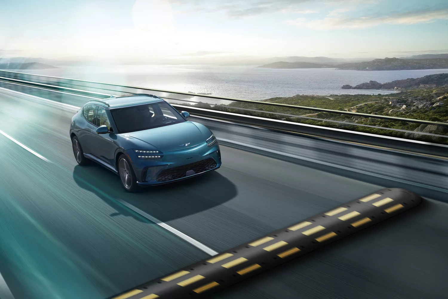 3/4 front passenger side view of 2026 Genesis GV60 in Tromso Green driving on coastal highway