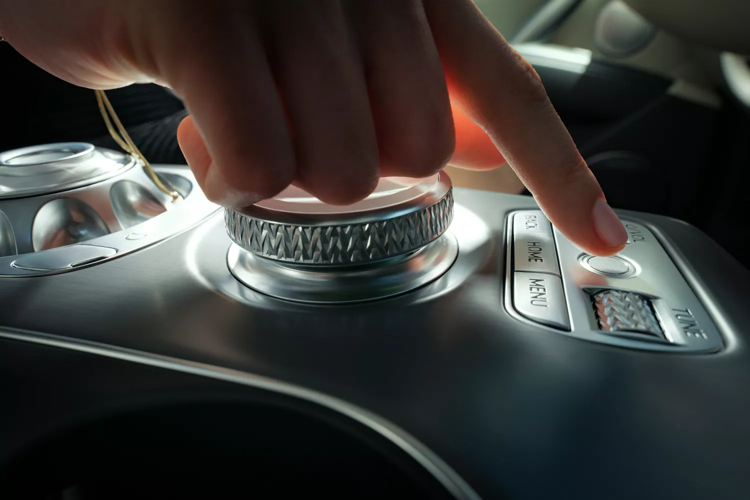 Interior close up of hand point to center console fingerprint reader, inside Genesis GV60