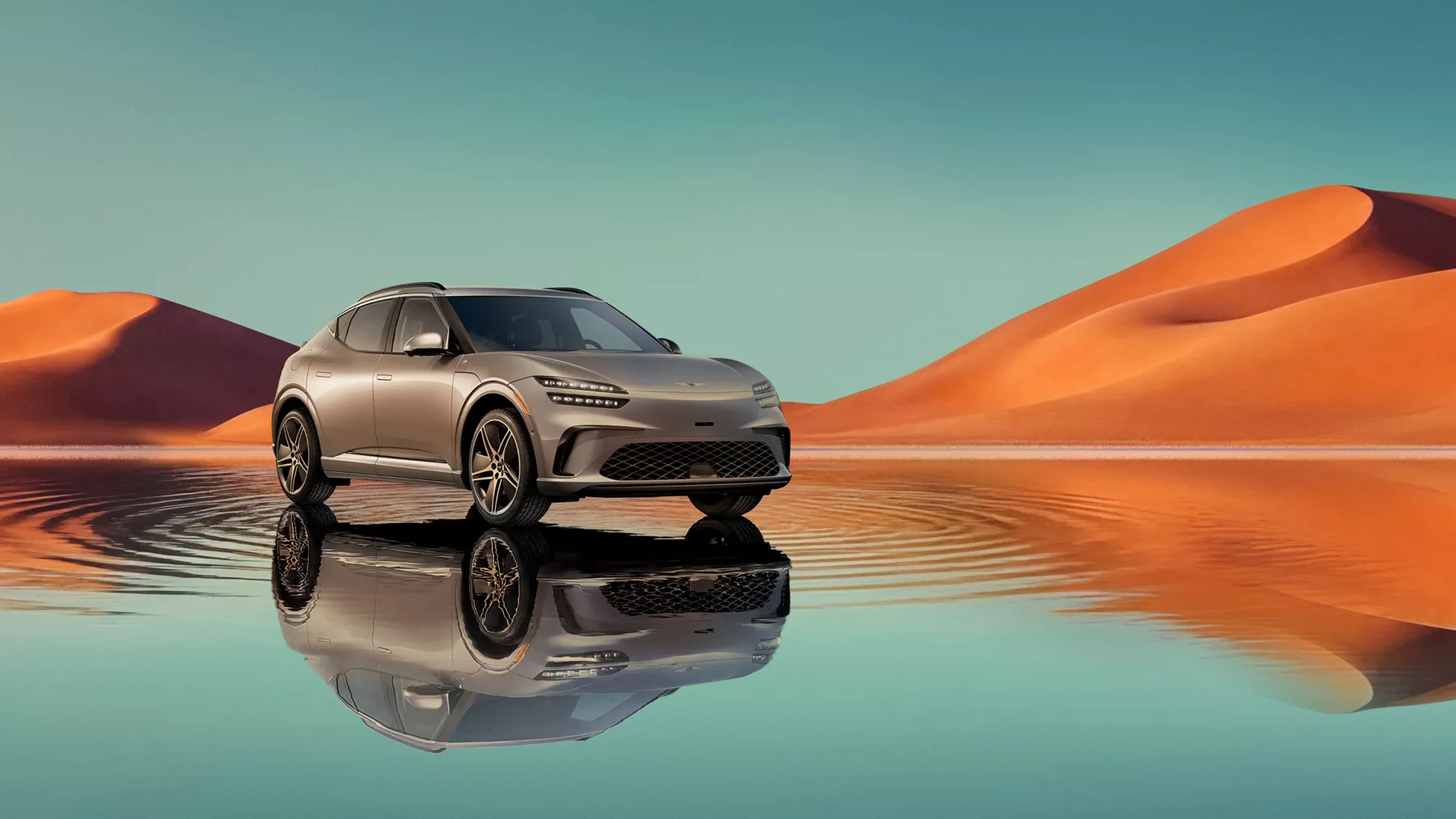 7/8 front passenger view of Savile Silver Genesis GV60 on blue lake w/ orange mountain in background