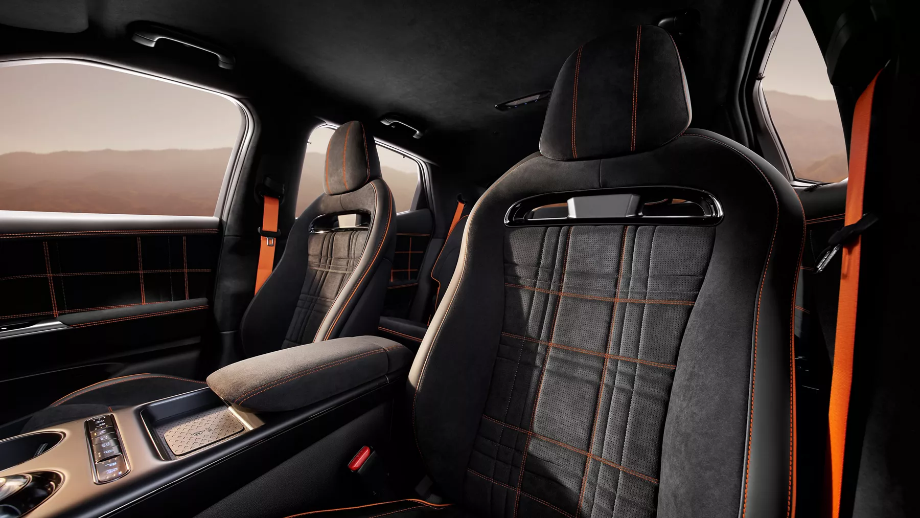 Interior view from driver seat looking to rear of 2027 Genesis GV60 Magma cockpit with orange accents